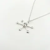 Collar con dije de pulpo plateado con piedra verde engarzada, con cadena de eslabones finos.