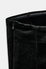 Top strapless confeccionado en tejido de terciopelo negro, con cierre frontal de botones metálicos dorados y bajo con abertura central.