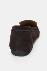 Zapato mocasín color marrón oscuro, de serraje, con detalle de tira en la parte delantera y acabado en punta redonda.