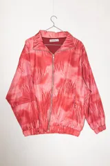 Campera con cierre frontal, cuello alto y bolsillos laterales. Estampado abstracto en tonos rojo y rosa.