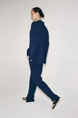 Pantalón de tiro medio con diseño de pierna ancha y textura acanalada. Cuenta con cintura elástica ajustable mediante cordones.