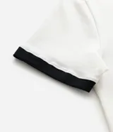 Remera de algodón color blanco con cuello y bordes de mangas en color negro. Presenta una estampa frontal central con el número 98 dentro de una estrella con efecto desgastado.