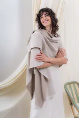 Ruana tejida en punto acanalado, con diseño bicolor en tonos crudo y beige, de caída fluida y envolvente.