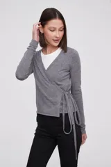 Saco tipo cardigan cruzado de punto, color gris melange, con escote en V profundo, mangas largas y lazo lateral para ajustar a la cintura.