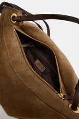 Bolso de mano formato alargado confeccionado en piel, con doble asa, una de mano y otra de hombro, con detalle de nudos y ojales metálicos. Cuenta con cierre mediante solapa y cremallera, y bolsillo interior con cremallera.