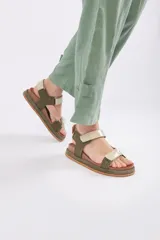 Sandalias planas tipo cangrejeras color verde militar y beige, con suela marrón y tiras ajustables con velcro.