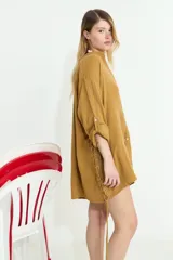 Camisa de algodón blanca, de manga larga y corte oversize, con diseño abierto en los laterales ajustable mediante cordón y ojalillos.