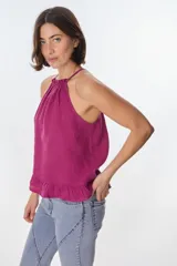 Musculosa color beige de lino, con cuello halter con volados y volados en el ruedo.