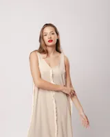 Vestido largo blanco de lino con escote en V y flecos de algodón en los bordes.