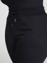 Pantalón babucha de algodón color negro, con cintura elástica con cordón ajustable y puños en los tobillos.