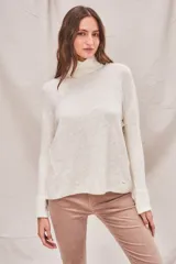 Sweater de punto color crema, con cuello alto y mangas largas.