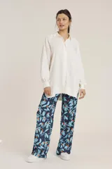 Camisa blanca de manga larga con cuello clásico y cierre frontal con botones.