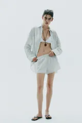 Short de algodón con estampado de rayas verticales finas en tonos verde menta y blanco. Presenta cintura elástica y corte holgado.