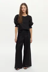 Pantalón de lino color negro, con elástico en la cintura, pinzas en el frente, pierna amplia y bolsillos frontales y traseros.