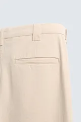Pantalón chino de corte recto confeccionado en tejido ligero de algodón con estructura canvas. Presenta bolsillos frontales, bolsillos traseros de vivo y cierre frontal con cremallera y botón.