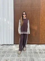 Conjunto de dos piezas en tejido de punto color beige, compuesto por un sweater de calce relajado con mangas a rayas y un pantalón de tiro alto con caída suelta y detalle lateral a rayas.