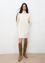 Vestido corto de punto color crudo, con cuello vuelto y mangas largas, de diseño recto y sin cierre.