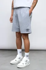 Bermuda deportiva Umbro de color celeste, con cintura elástica con cordón ajustable y el logo de la marca bordado en blanco en la parte inferior de la pierna izquierda.