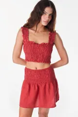 Minifalda de lino color rojo, de tiro alto con pretina fruncida y diseño holgado.