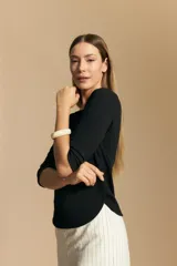 Remera de tejido acanalado (rib) color blanco, con escote cuadrado y mangas tres cuartos, de ajuste entallado al cuerpo.