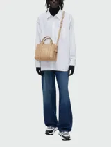Cartera tipo tote de Marc Jacobs, confeccionada en cuero granulado negro. Presenta el logo de la marca estampado en el frente y doble asa superior.