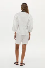 Camisa de lino blanca con mangas abullonadas y diseño para anudar al frente.