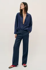 Camisa de corte amplio confeccionada en algodón, con cuello solapa, manga larga, bolsillo delantero de plastrón y cierre frontal con botones.