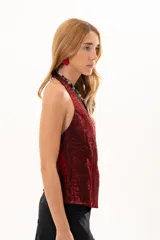 Chaleco de corte sastrero en color bordó, con acabado satinado y textura arrugada. Presenta escote en V profundo, cierre frontal con botones y diseño sin mangas.