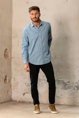 Camisa celeste de manga larga con cuello clásico y cierre frontal con botones.