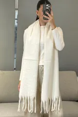 Bufanda de tejido grueso y suave, color blanco, con diseño de flecos en los extremos.