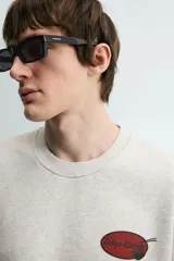 Sudadera gris de corte relaxed fit, cuello redondo y manga corta. Presenta un estampado en el pecho con la frase "Tokyo Kitchen" en un óvalo rojo con palillos.