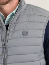 Chaleco gris acolchado para hombre, confeccionado en nylon reciclado repelente al agua, con cierre de cremallera, sisa elástica y logo engomado en el pecho.