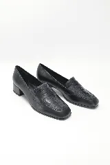 Mocasín de cuero negro liso combinado con cuero texturado en la capellada, con punta redondeada y taco medio ancho.