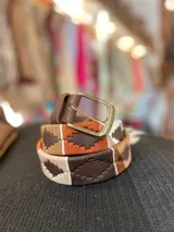 Cinturón unisex de cuero marrón con detalles bordados a mano en tonos naranja, marrón oscuro, tostado y blanco formando un patrón geométrico. Cuenta con hebilla metálica de acabado envejecido.