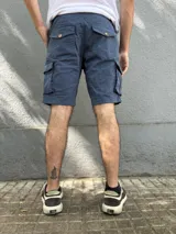 Bermuda cargo de corte regular color azul, con bolsillos laterales con solapa y cierre frontal con botón y cremallera.