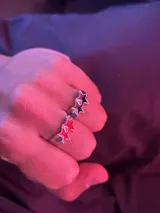Set de dos anillos de metal plateado con diseño de estrellas esmaltadas en colores rojo y negro.