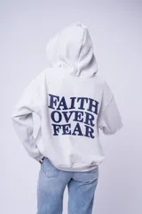 Canguro con capucha color blanco, confeccionado en algodón, con bolsillo frontal tipo canguro y pequeño bordado en el pecho.