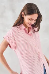 Blusa de viscosa con estampado de rayas verticales en color blanco y rosado, cuello camisero, cierre frontal con botones y mangas cortas con dobladillo.