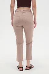 Pantalón jean de tiro alto y corte recto, color blanco, con bolsillos laterales y traseros, y terminación desmechada en los tobillos.