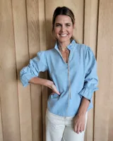 Blusa de algodón con cuello mao y volados, mangas largas con puños elásticos y corte holgado.