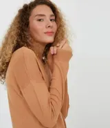 Sweater color marrón de punto con cuello redondo y mangas largas.