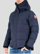 Campera puffer azul marino con capucha, cierre frontal con cremallera y broches, bolsillos laterales con solapa y logo de la marca en el brazo izquierdo.