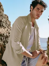 Camisa de manga larga confeccionada en una mezcla de lino y viscosa, de color beige. Presenta un diseño de calce relajado con cuello camisero, cierre frontal de botones y mangas con trabilla y botón para sujetar el doblez.