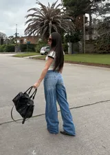 Jean de tiro medio con corte wide leg, color azul lavado, con estampado de alas en la parte trasera.