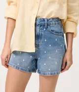Short de jean color azul con corte evasé y bordado de lunares blancos en toda la prenda. Cuenta con pasacintos, bolsillos delanteros y traseros.