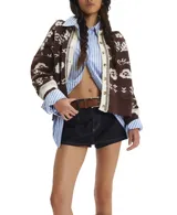 Cárdigan de tejido de punto grueso, color marrón oscuro con estampado jacquard en blanco de motivos florales y náuticos. Presenta cuello camisero y cierre frontal de botones.