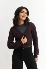 Cárdigan color borgoña de tejido de punto con textura acanalada, escote en V, cierre frontal con botones y mangas largas abullonadas.
