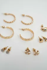 Set de aros variados en tono dorado, que incluye aros tipo argolla trenzados, argollas lisas, aros tipo gota, aros con piedras brillantes, aros con perlas y aros con diseño floral.