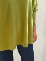 Sweater de punto color verde pistacho, con cuello redondo, mangas largas con puños ajustados y diseño holgado de corte oversize.