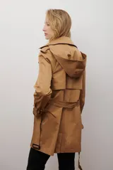 Trench coat negro de corte midi, con cuello solapa, cierre frontal cruzado con botones y cintas ajustables en los puños.